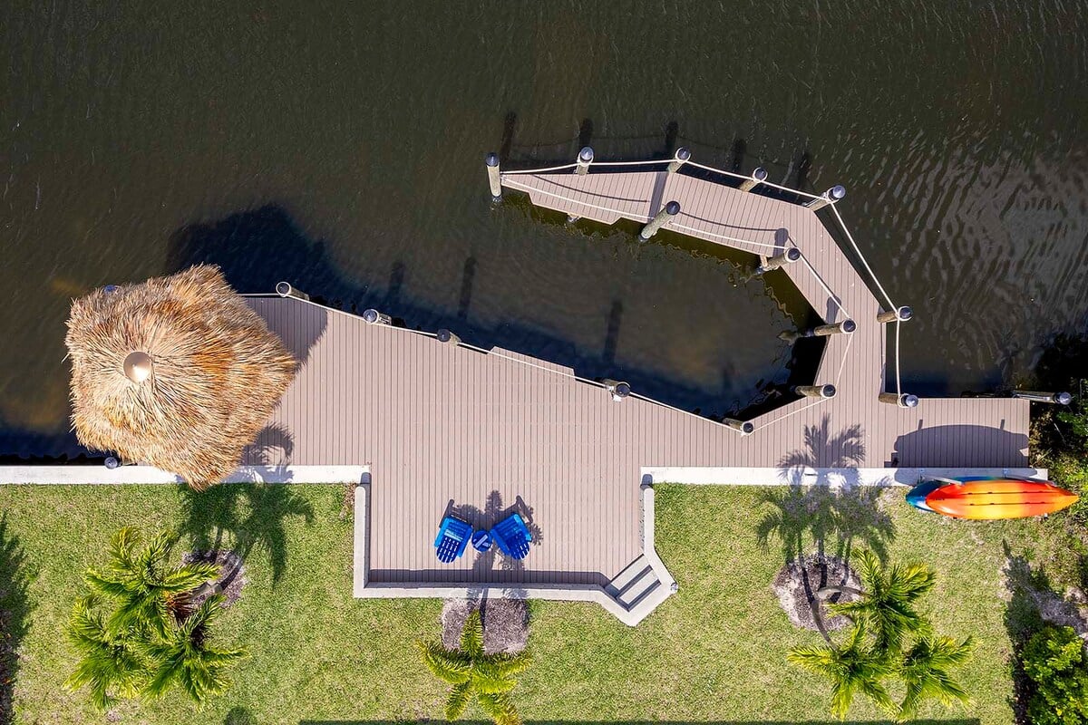 Blick auf den Kanal vom Außenbereich mit Pool und Sonnenliegen.