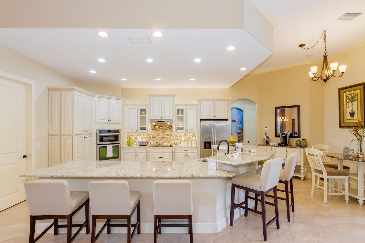 Südost-ausgerichteter Poolbereich am Kanal mit Veranda, Esstisch und Grill.