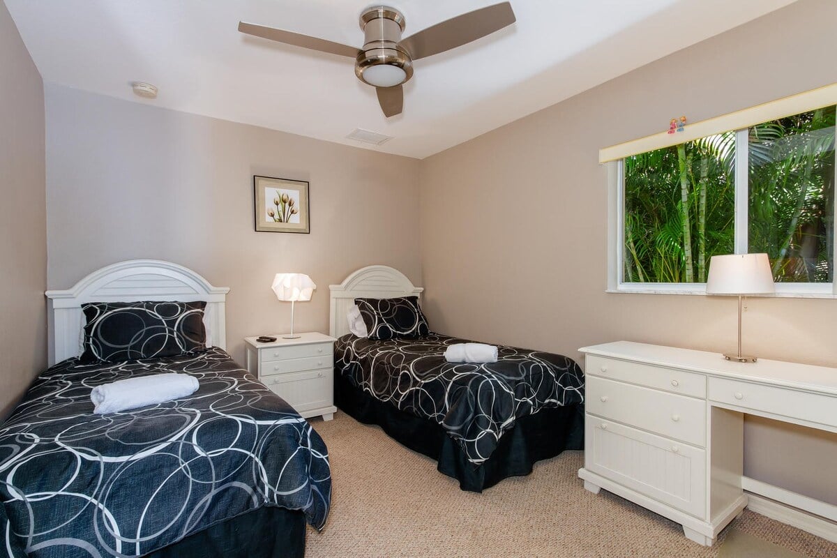 Gästezimmer mit zwei Einzelbetten, Schreibtisch und Gartenblick