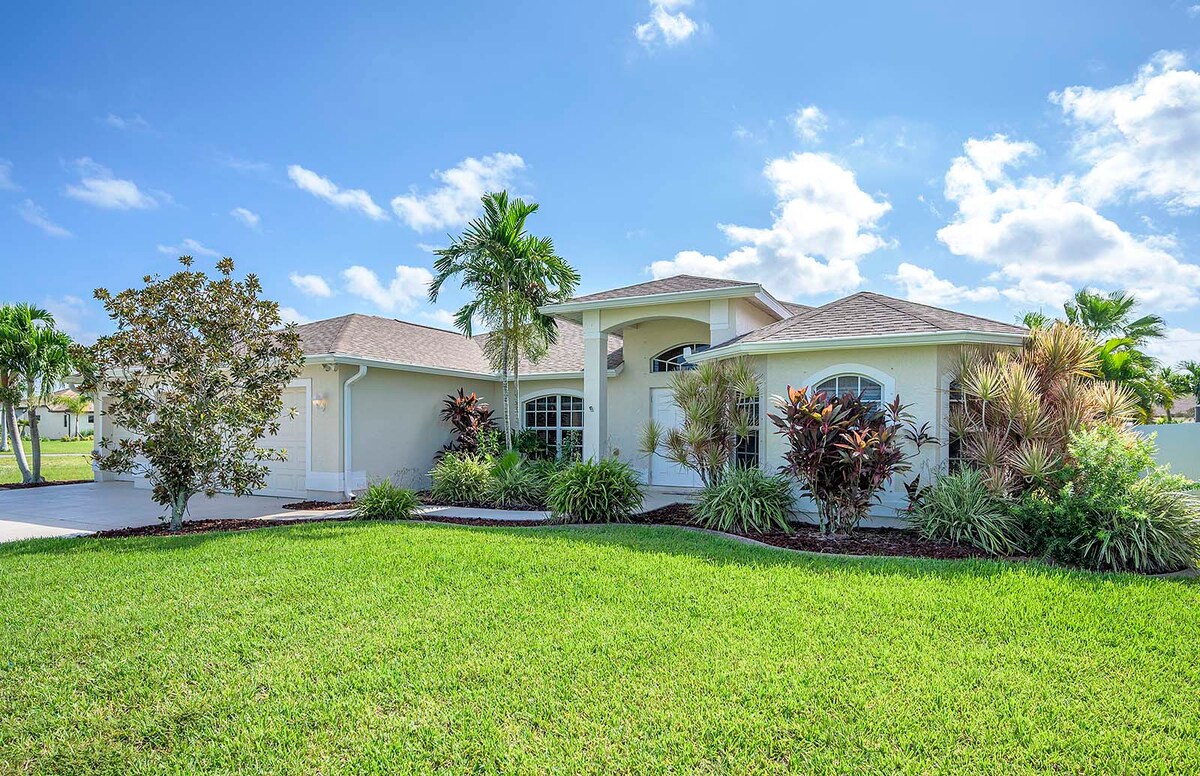 Überdachte Veranda mit Sitzbereich und Blick in den eingezäunten Garten.