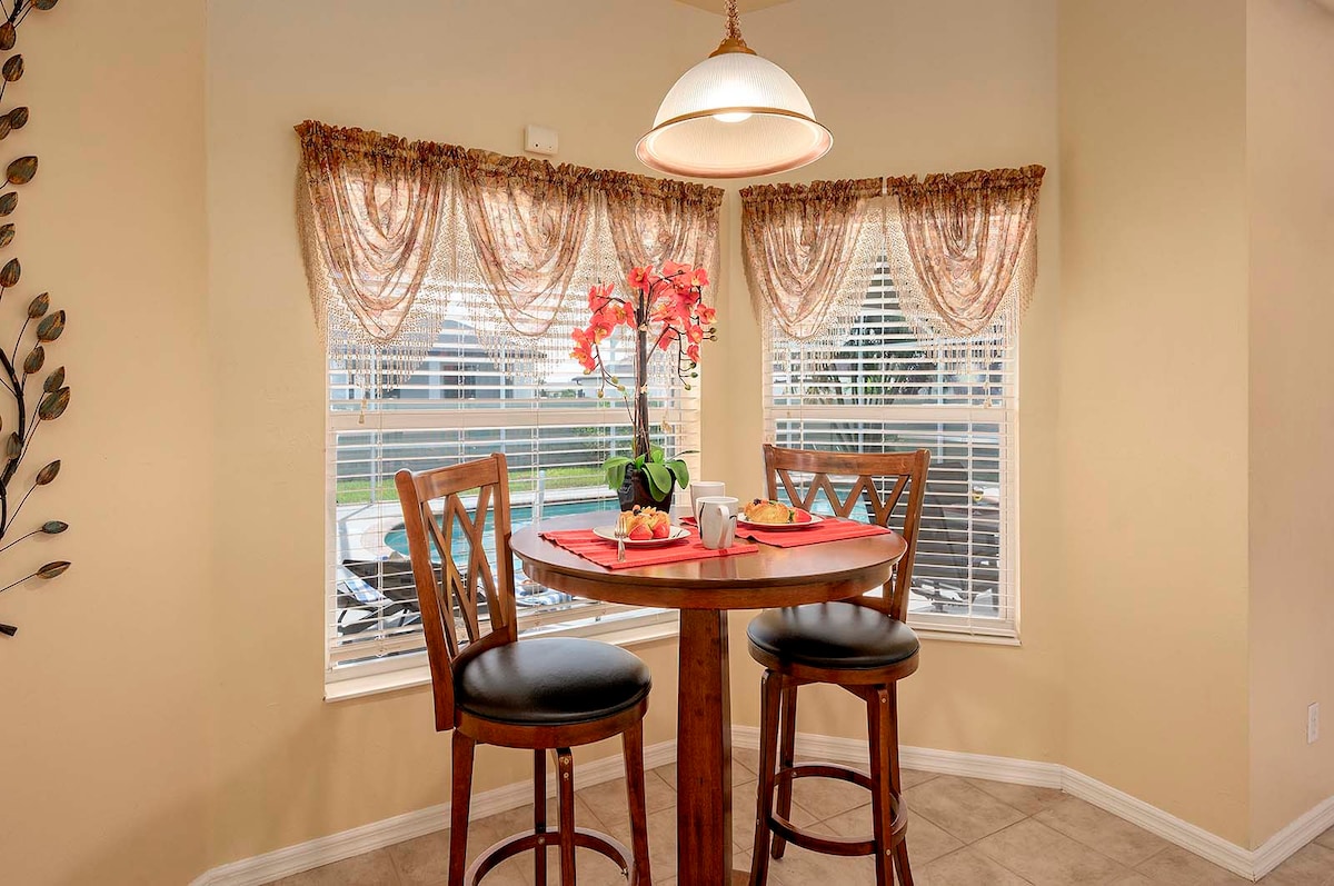 Überdachte Veranda mit Sitzbereich und Blick in den eingezäunten Garten.