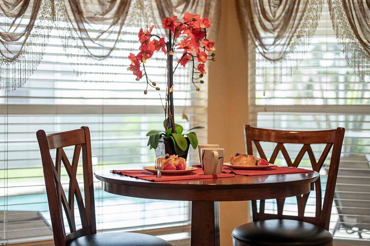 Überdachte Veranda mit Sitzbereich und Blick in den eingezäunten Garten.