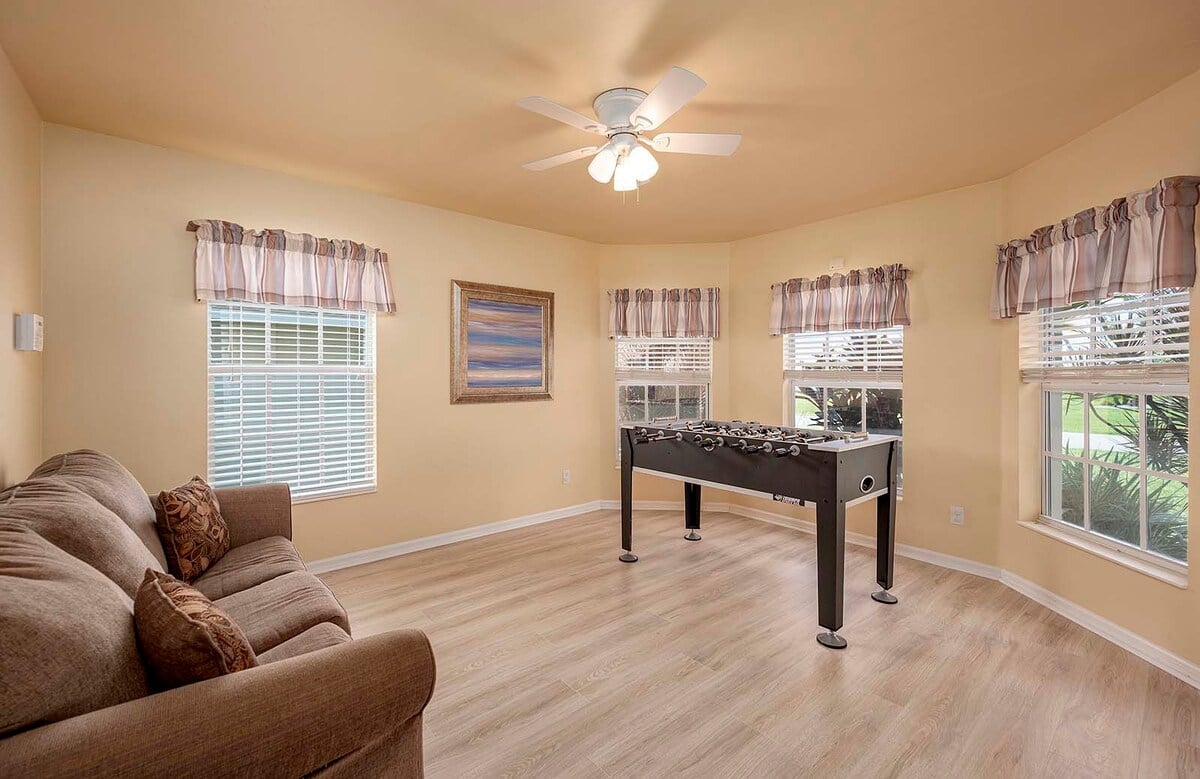 Überdachte Veranda mit Sitzbereich und Blick in den eingezäunten Garten.