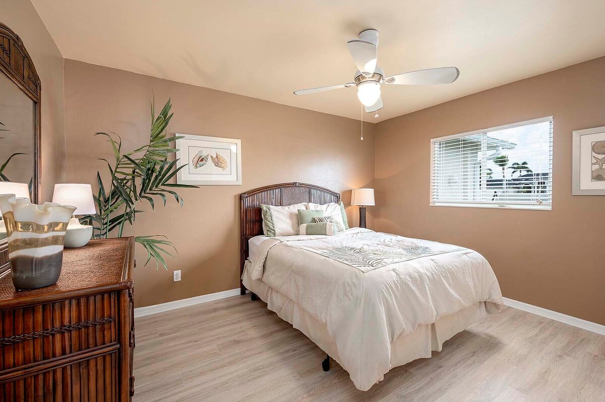 Überdachte Veranda mit Sitzbereich und Blick in den eingezäunten Garten.