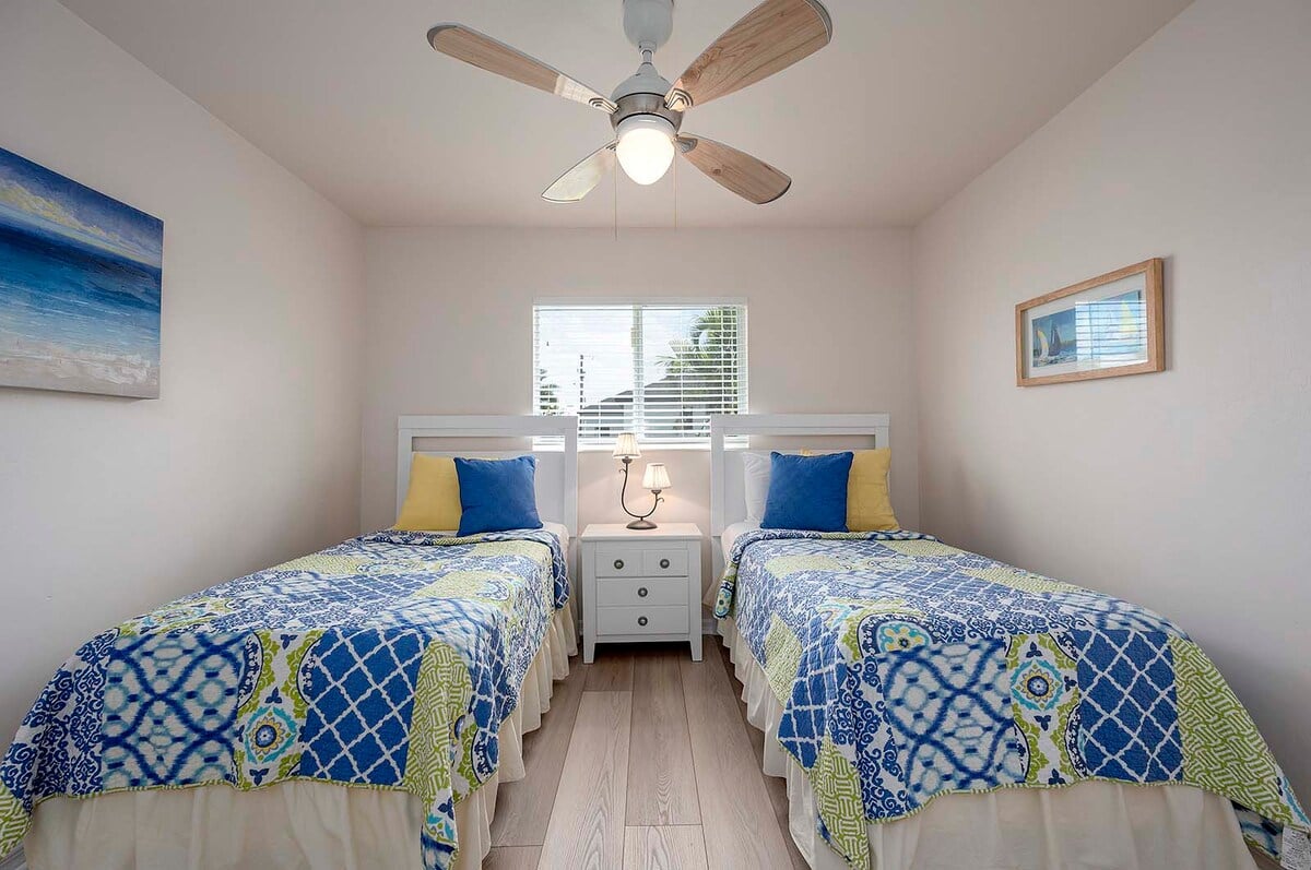 Überdachte Veranda mit Sitzbereich und Blick in den eingezäunten Garten.