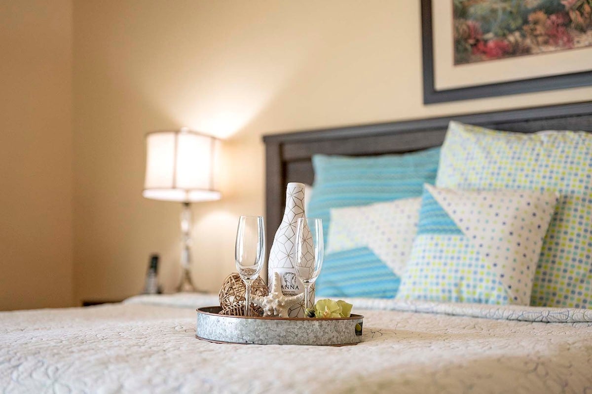 Überdachte Veranda mit Sitzbereich und Blick in den eingezäunten Garten.