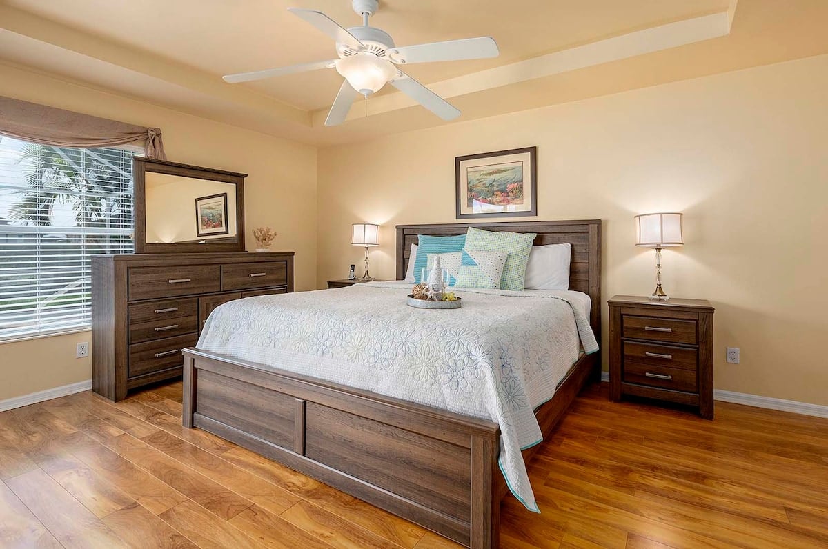 Überdachte Veranda mit Sitzbereich und Blick in den eingezäunten Garten.