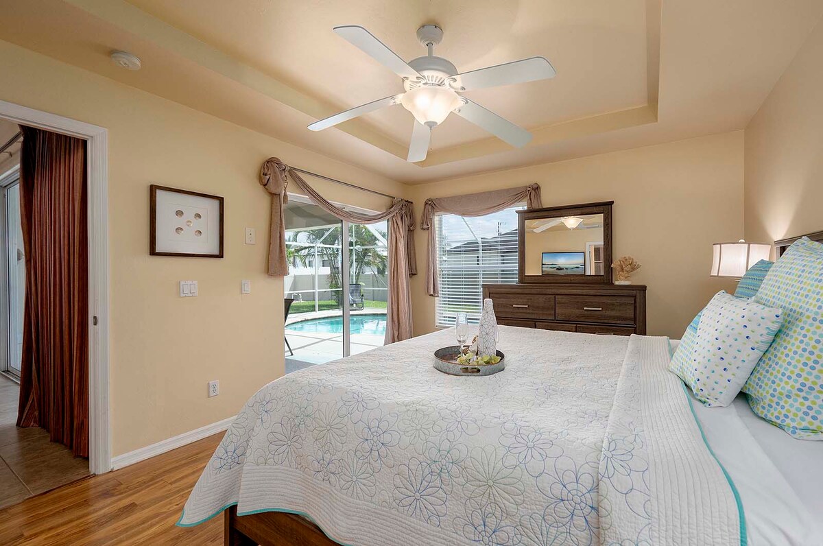 Überdachte Veranda mit Sitzbereich und Blick in den eingezäunten Garten.