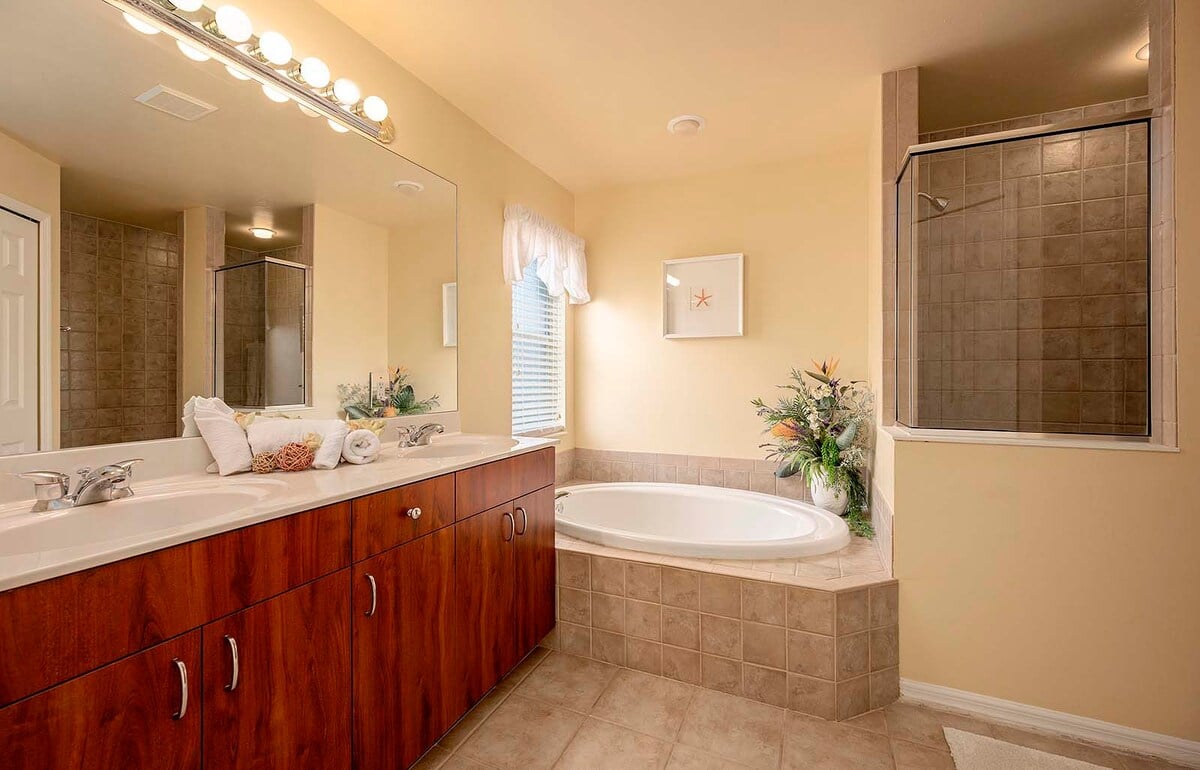 Überdachte Veranda mit Sitzbereich und Blick in den eingezäunten Garten.