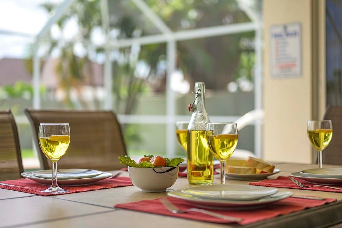Überdachte Veranda mit Sitzbereich und Blick in den eingezäunten Garten.