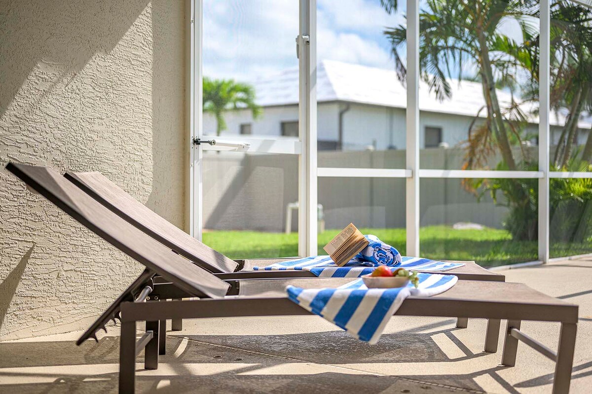 Überdachte Veranda mit Sitzbereich und Blick in den eingezäunten Garten.