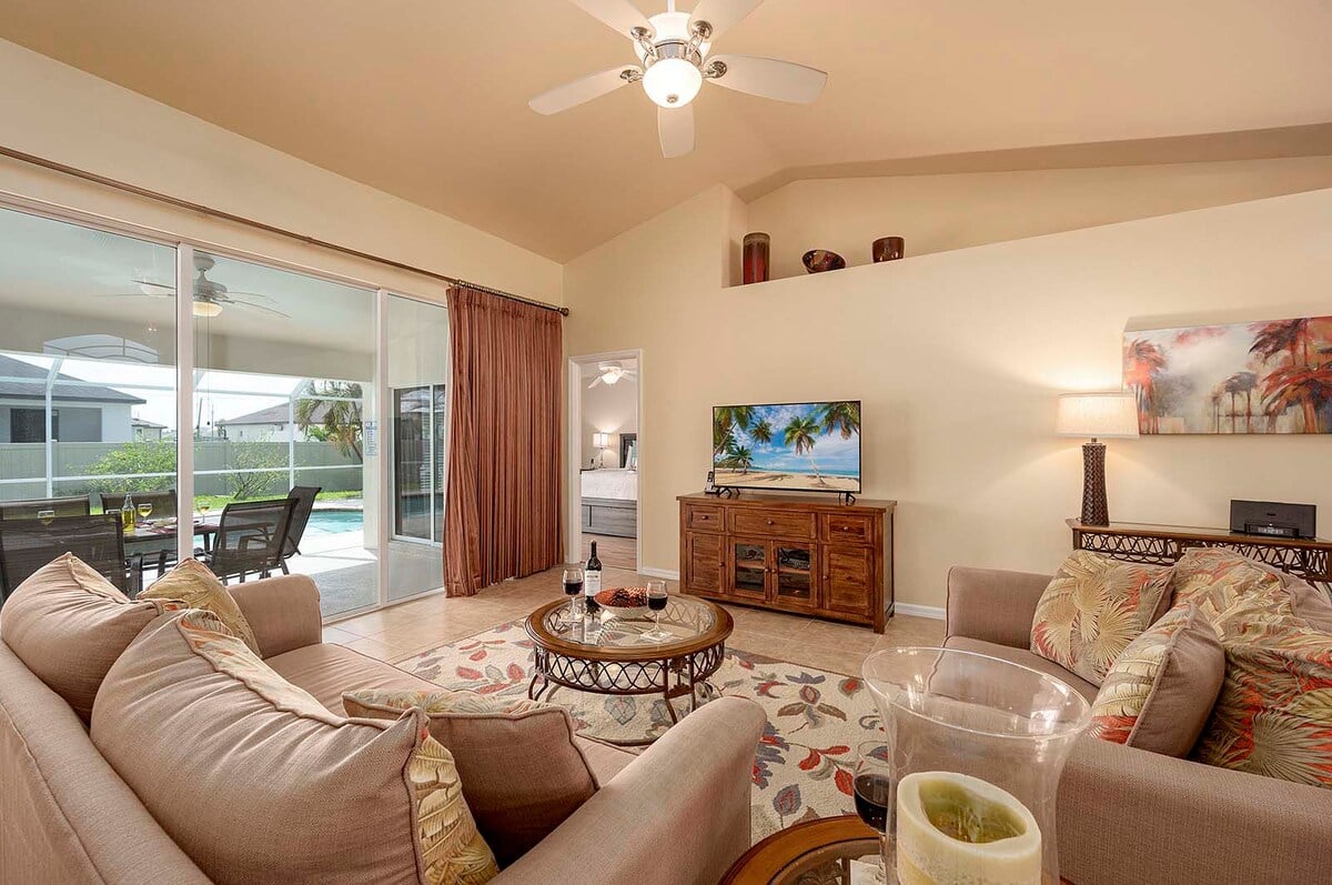 Überdachte Veranda mit Sitzbereich und Blick in den eingezäunten Garten.