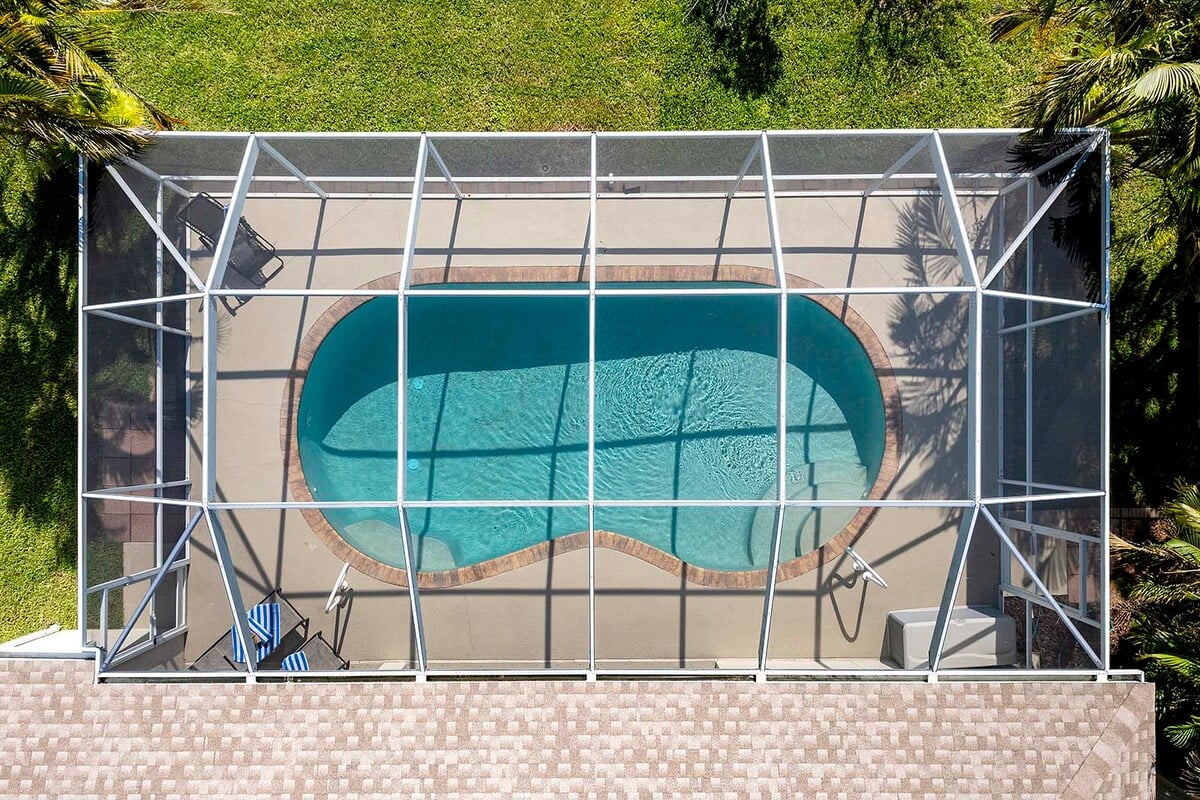 Überdachte Veranda mit Sitzbereich und Blick in den eingezäunten Garten.