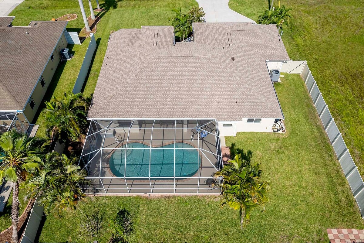 Überdachte Veranda mit Sitzbereich und Blick in den eingezäunten Garten.