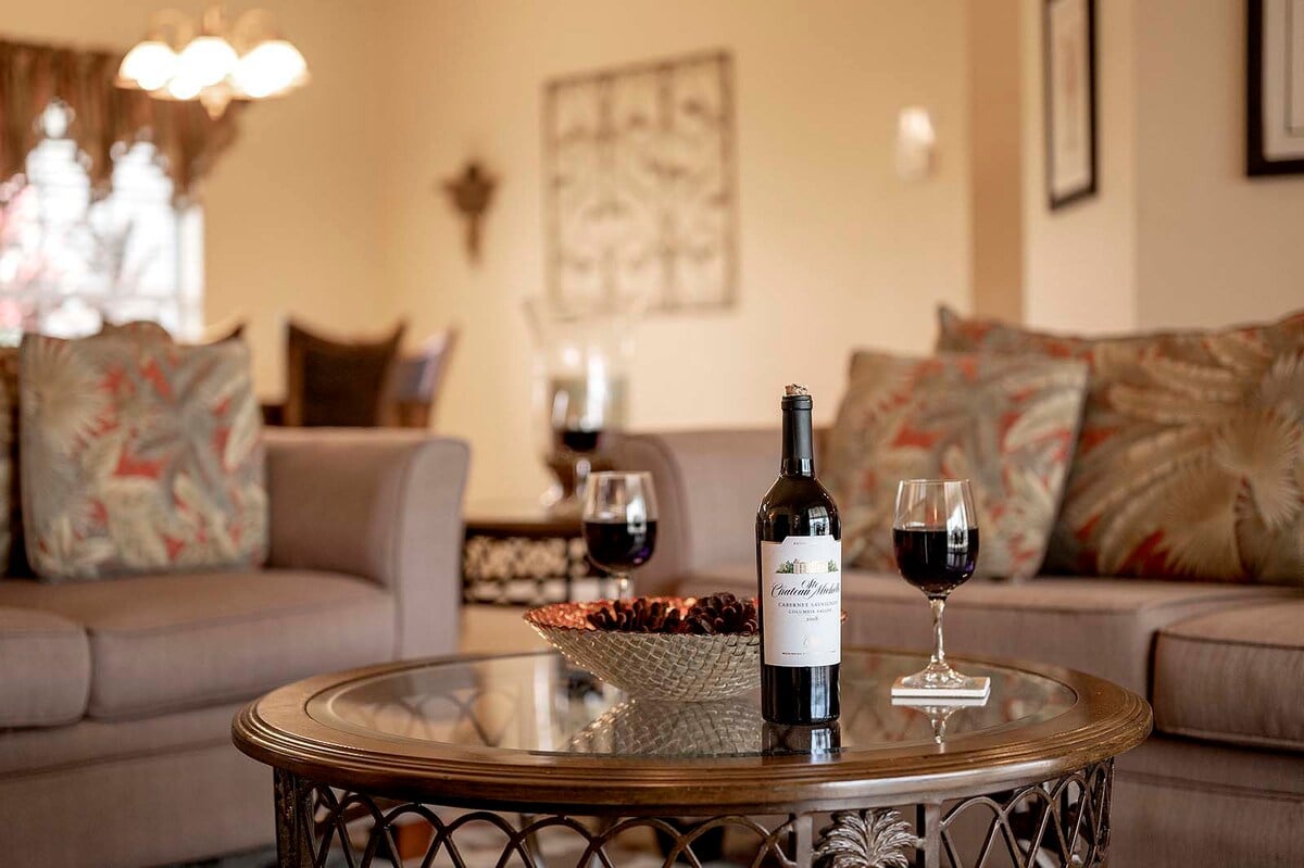 Überdachte Veranda mit Sitzbereich und Blick in den eingezäunten Garten.