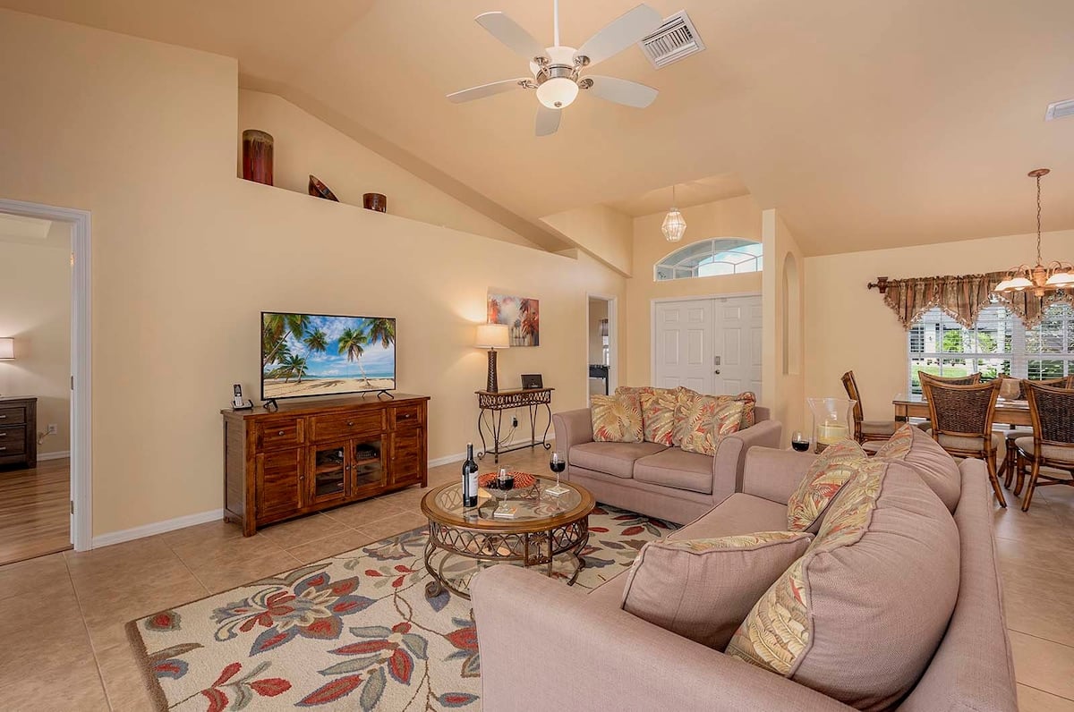 Überdachte Veranda mit Sitzbereich und Blick in den eingezäunten Garten.