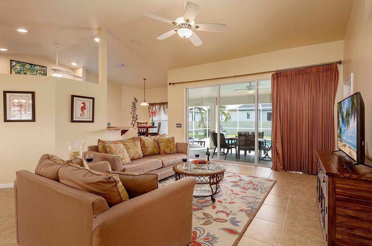 Überdachte Veranda mit Sitzbereich und Blick in den eingezäunten Garten.