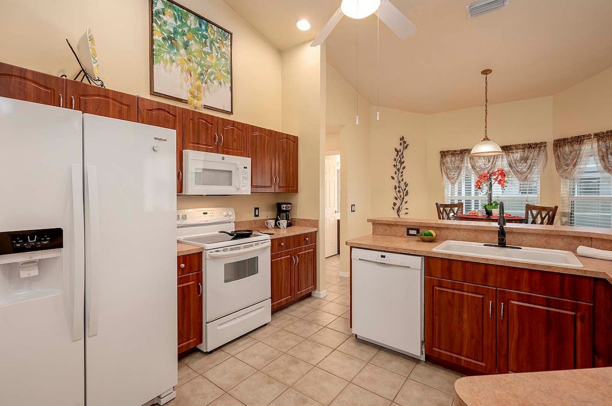 Überdachte Veranda mit Sitzbereich und Blick in den eingezäunten Garten.