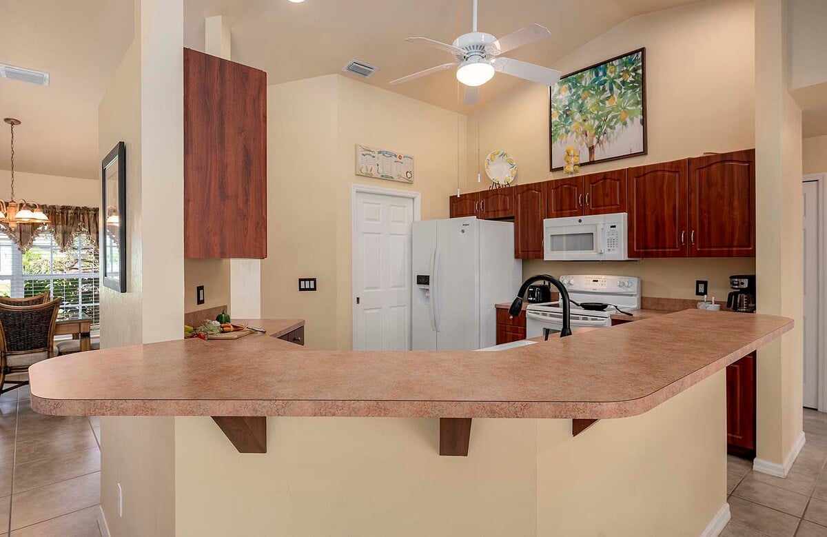 Überdachte Veranda mit Sitzbereich und Blick in den eingezäunten Garten.