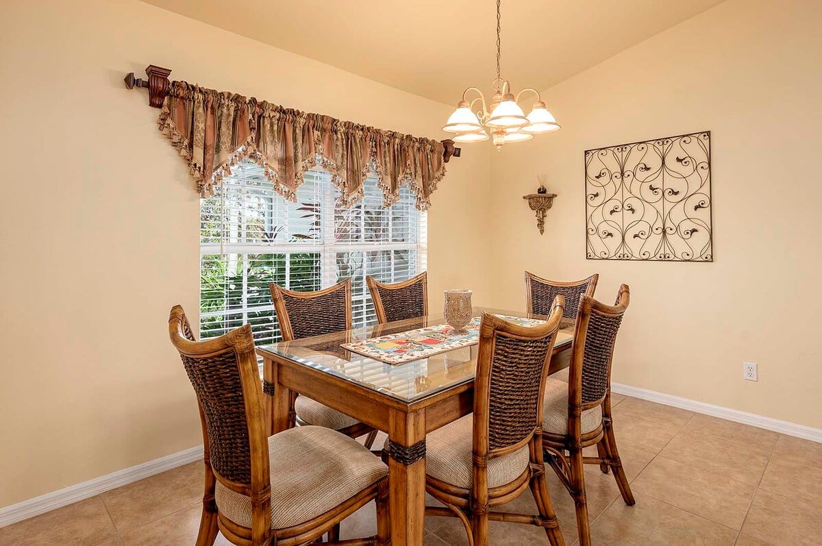 Überdachte Veranda mit Sitzbereich und Blick in den eingezäunten Garten.