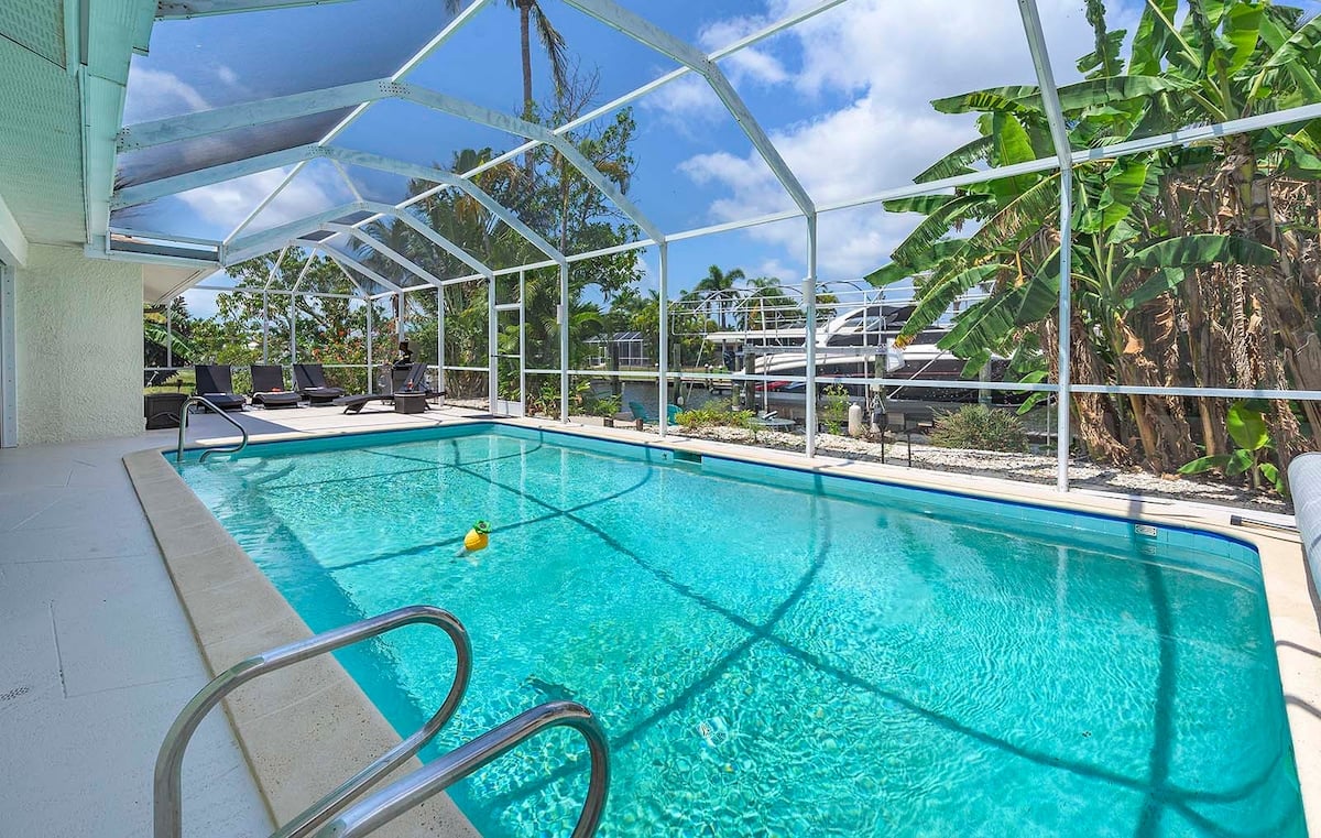 Privater Pool mit Sonnenliegen und Blick auf den Kanal.