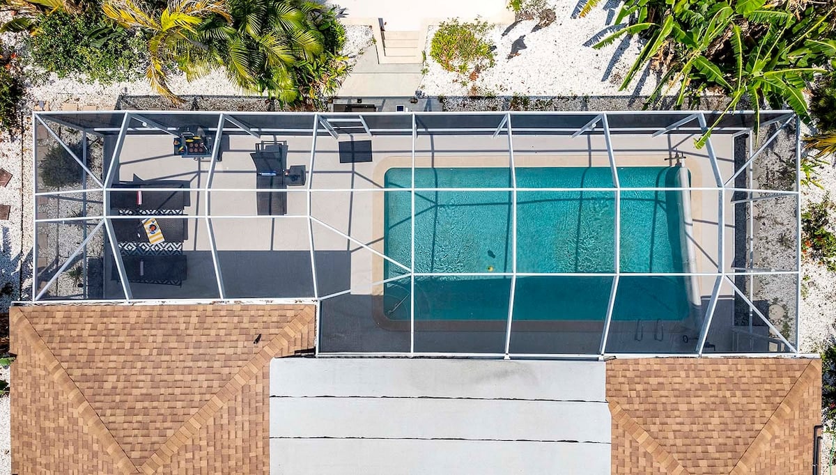 Privater Poolbereich mit Sonnenliegen und Blick auf den Kanal