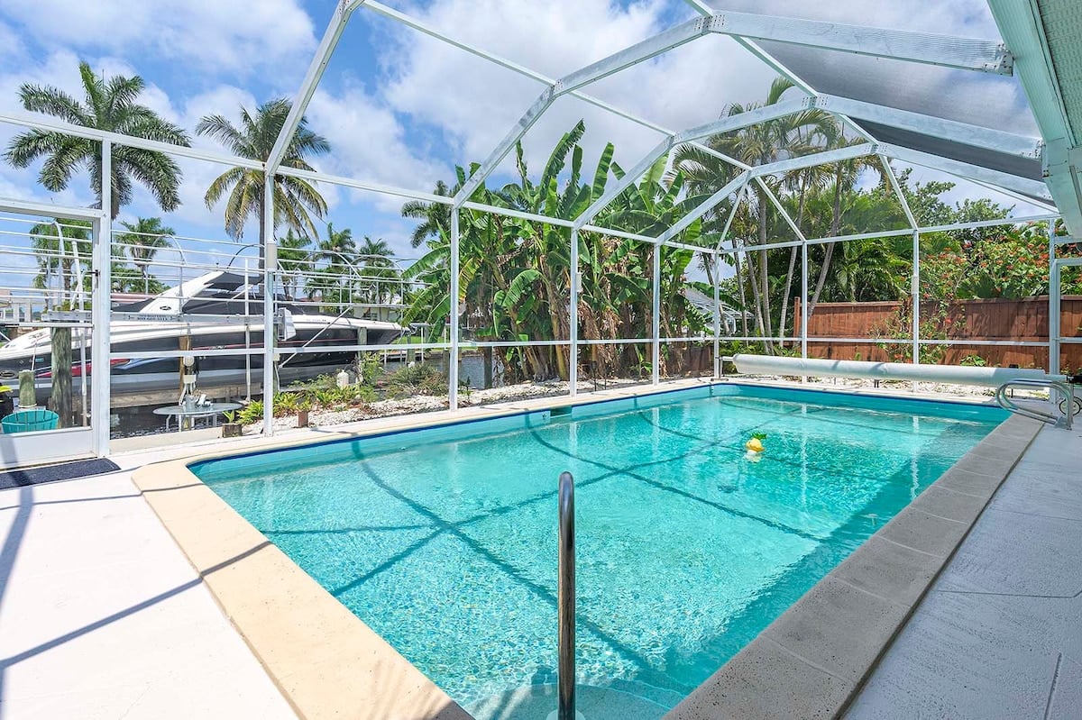 Privater Pool mit Sonnenliegen und Blick auf den Kanal.