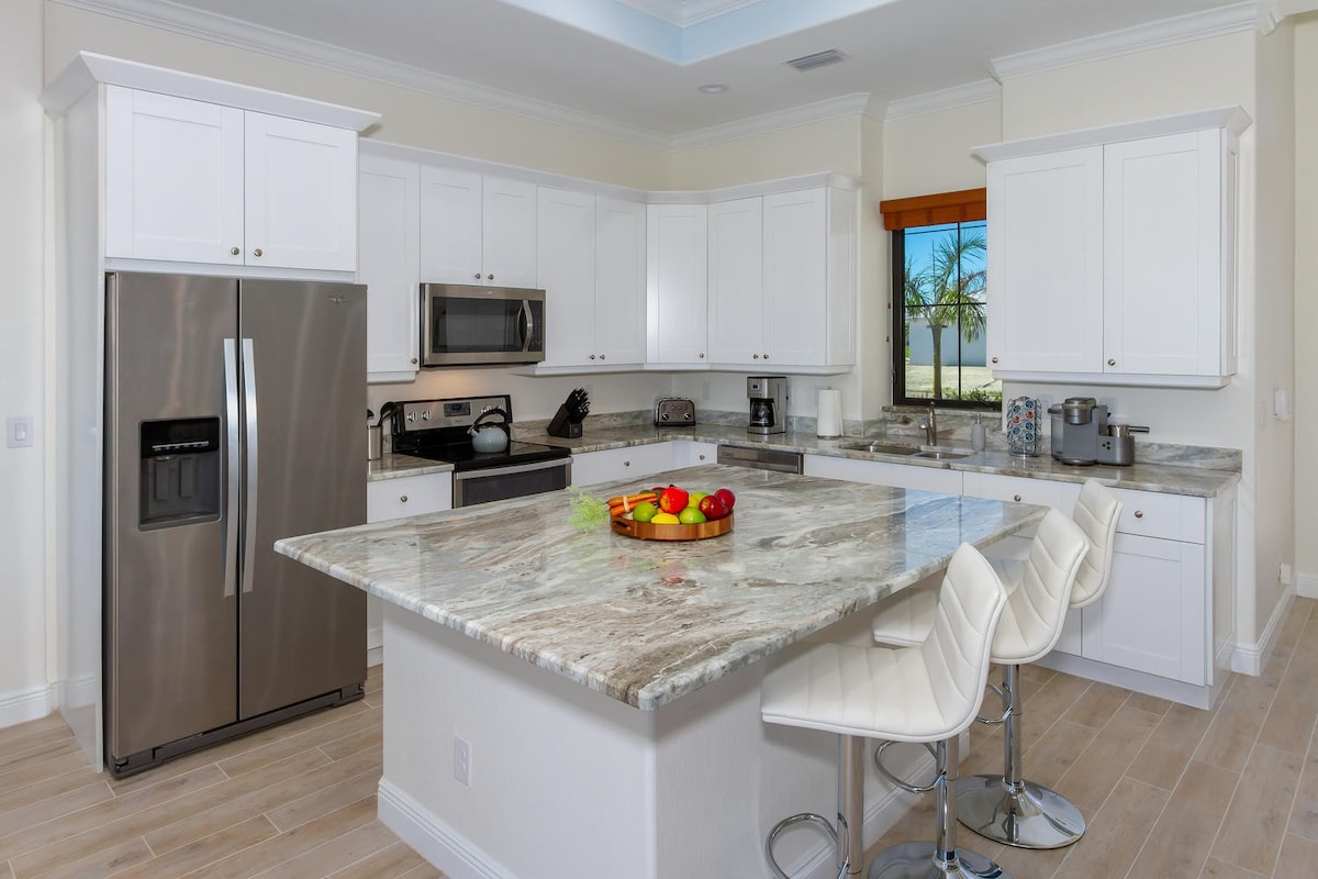 Blick vom Kanal auf das Bootsdock und die Terrasse mit Pool.