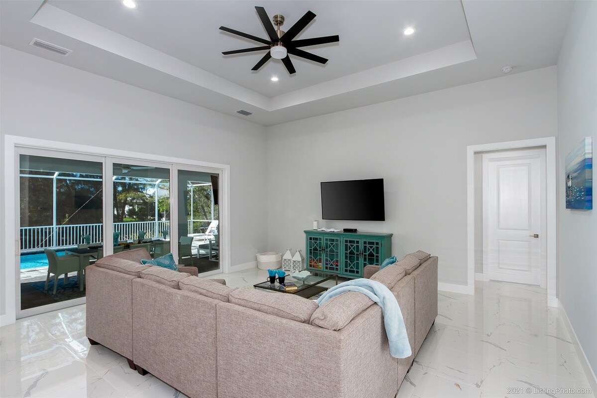 Terrasse mit Sitzbereich und Blick auf den Kanal bei Sonnenuntergang.