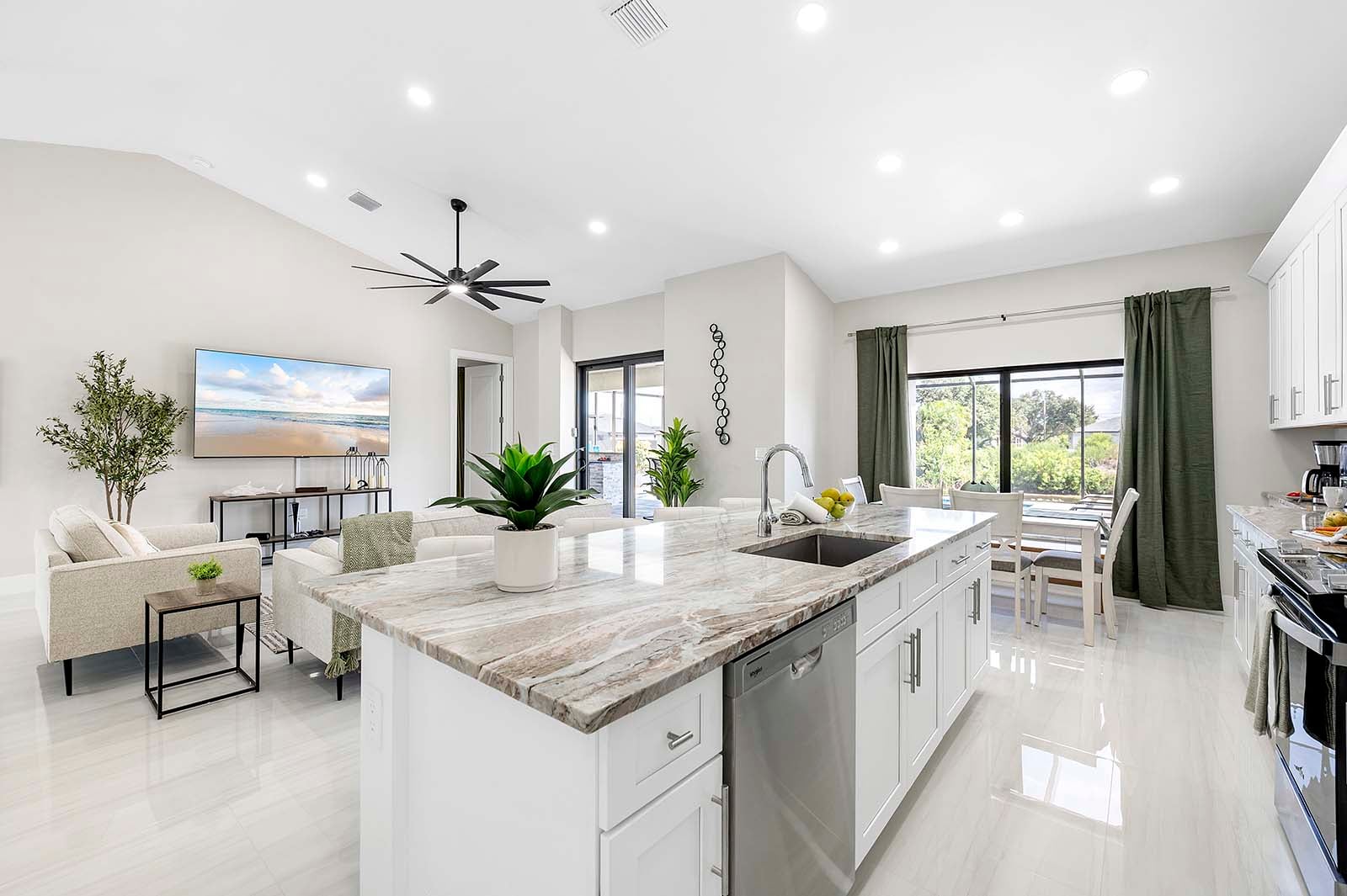 Großer Poolbereich mit Sonnenliegen, Outdoor-Küche und TV auf der Lanai.