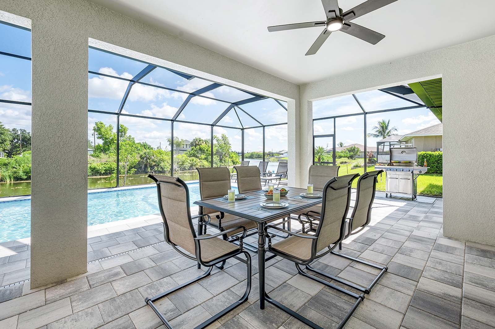 Poolbereich mit Outdoor-Küche, Grill und TV auf der überdachten Lanai.