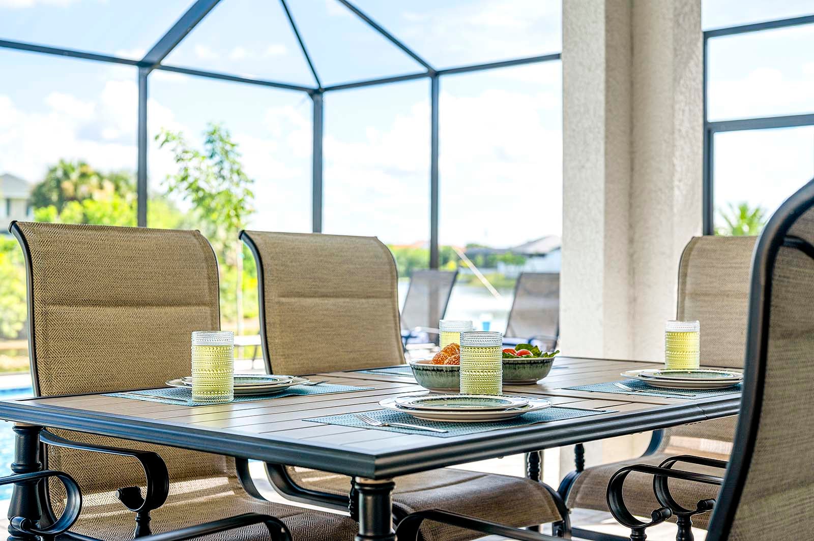 Großer Pool mit Sonnenliegen und überdachter Lanai am Kanal.