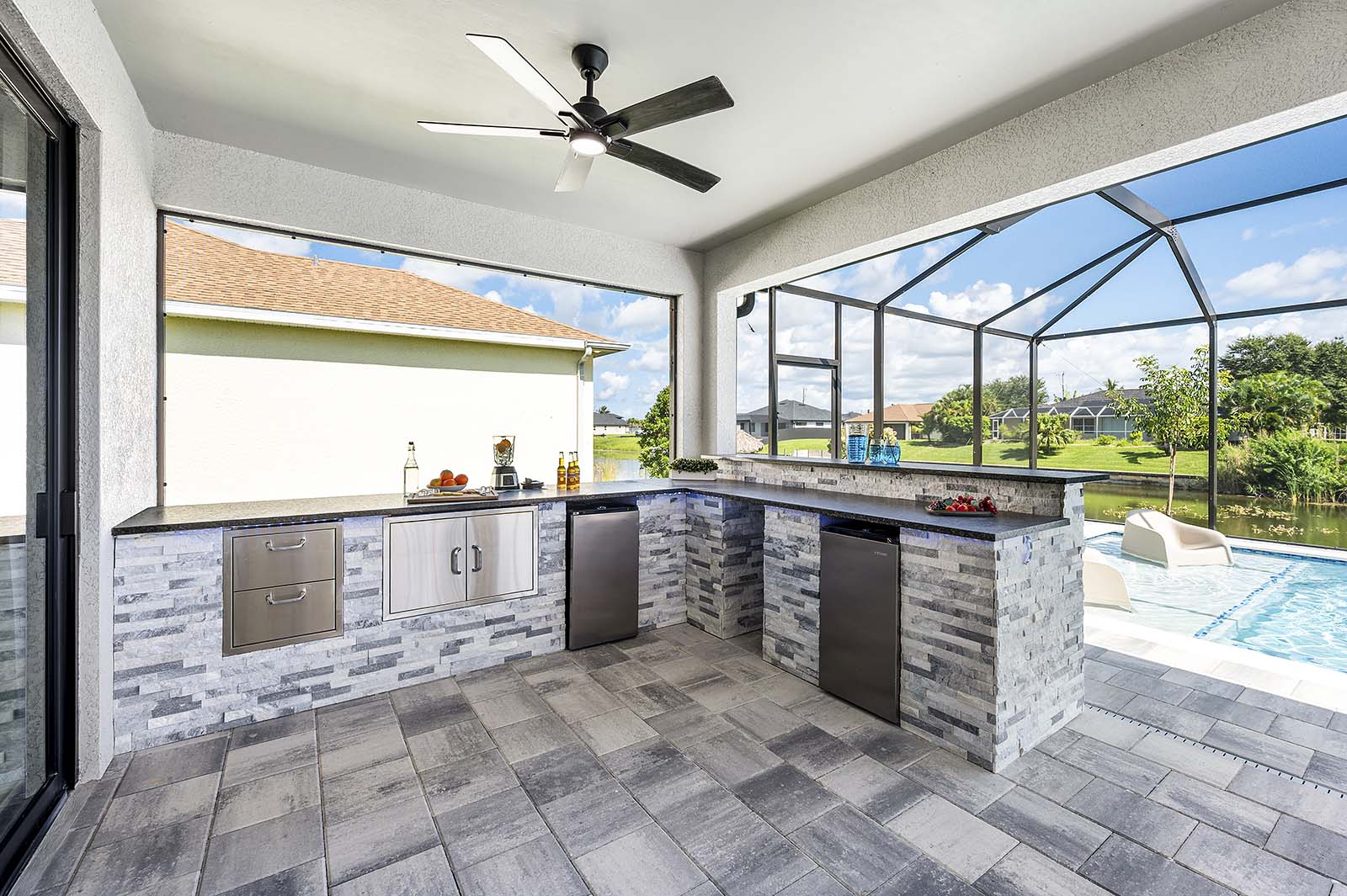 Großer Pool mit Sonnenliegen und überdachter Lanai am Kanal.