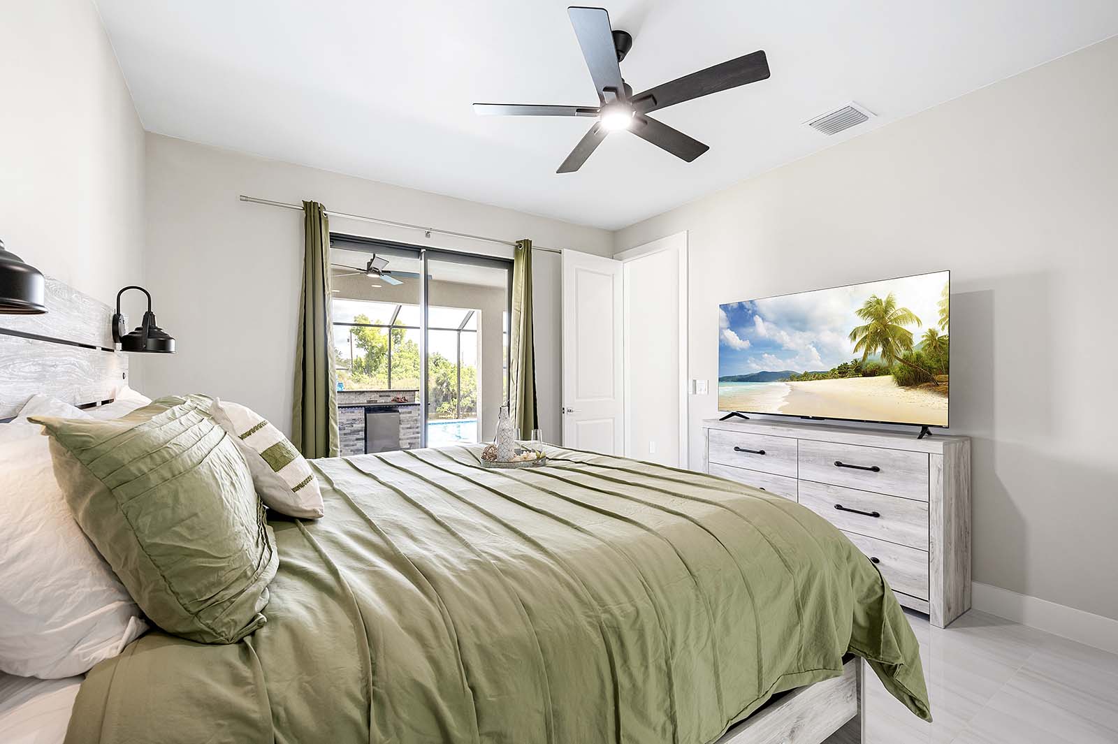 Großer Poolbereich mit Sonnenliegen, Outdoor-Küche und TV auf der Lanai.