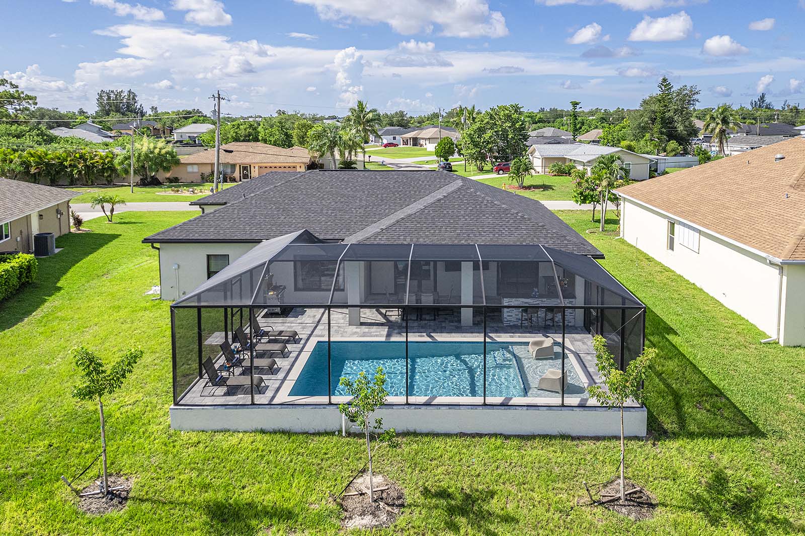 Poolbereich mit Outdoor-Küche, Grill und TV am Kanal.