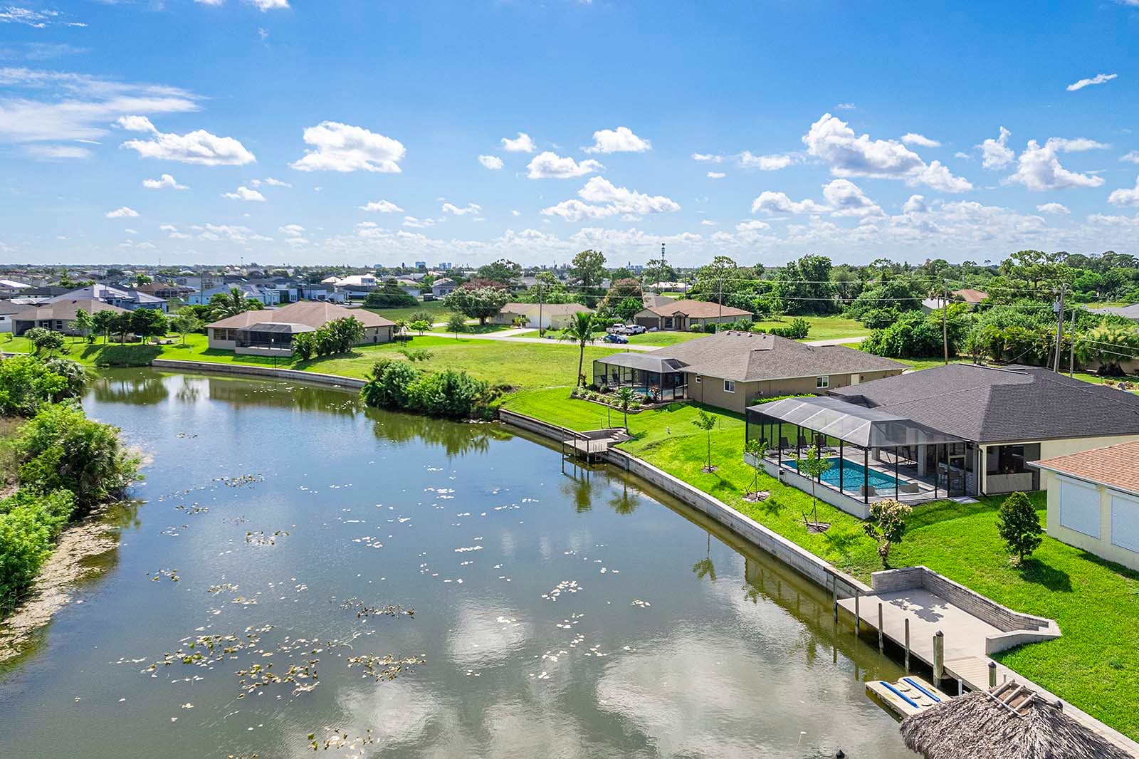 Poolbereich mit Outdoor-Küche, Grill und TV unter der überdachten Lanai.