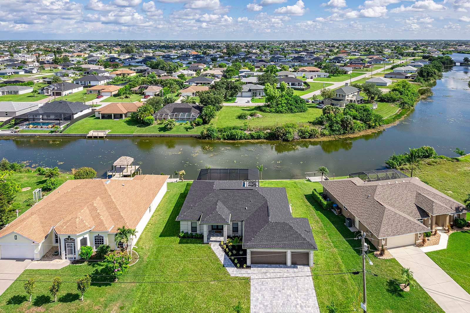 Poolbereich mit Outdoor-Küche, Grill und TV unter der überdachten Lanai.