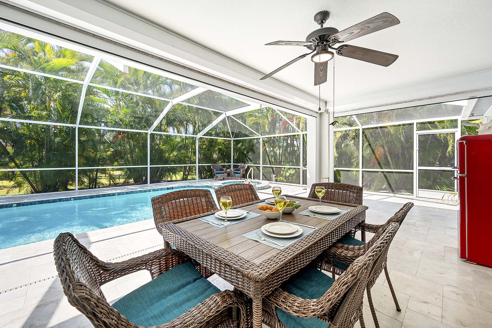 Überdachte Lanai mit Esstisch und Blick auf den Pool.
