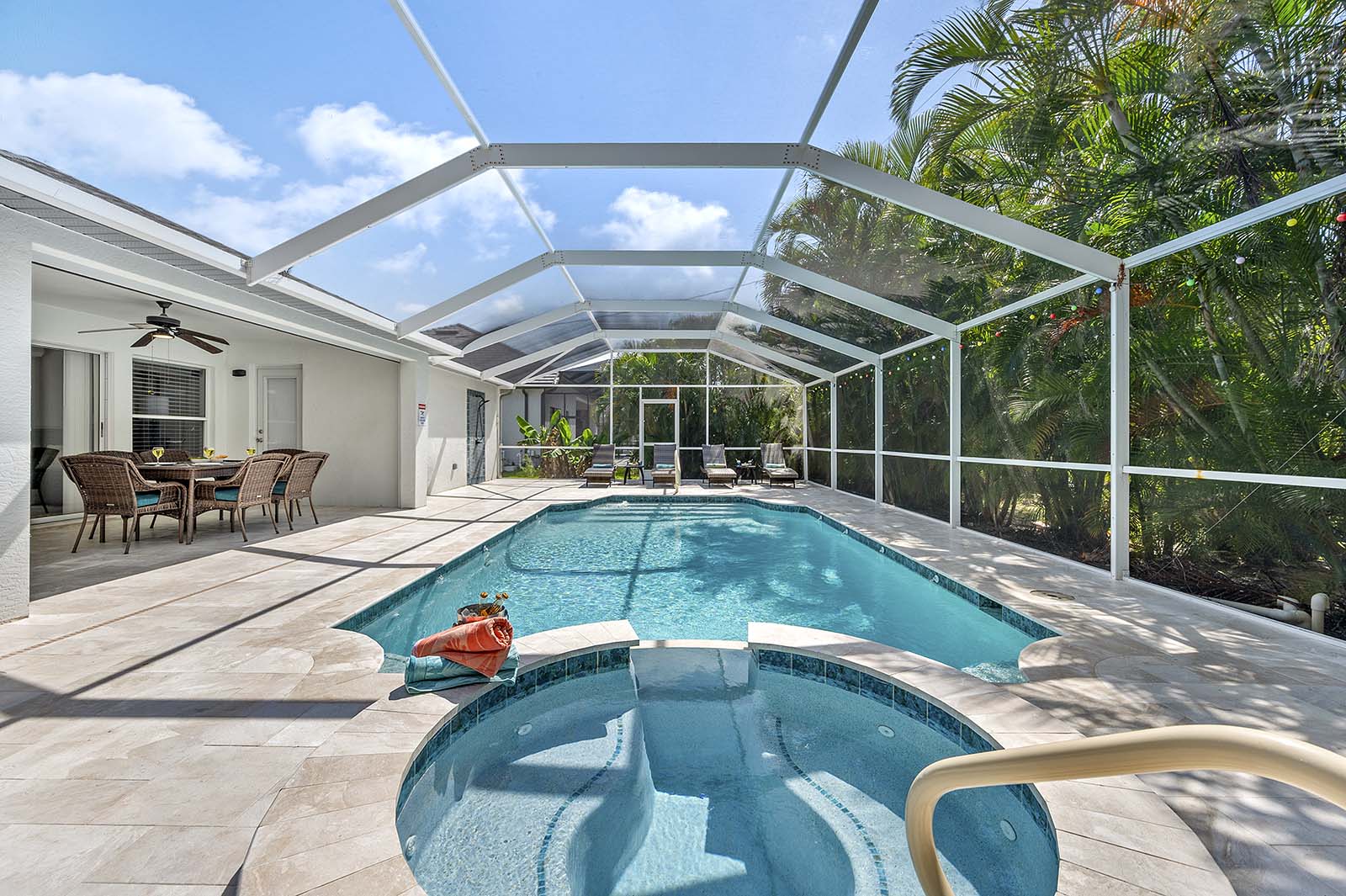 Überdachte Lanai mit Esstisch und Blick auf den Poolbereich.