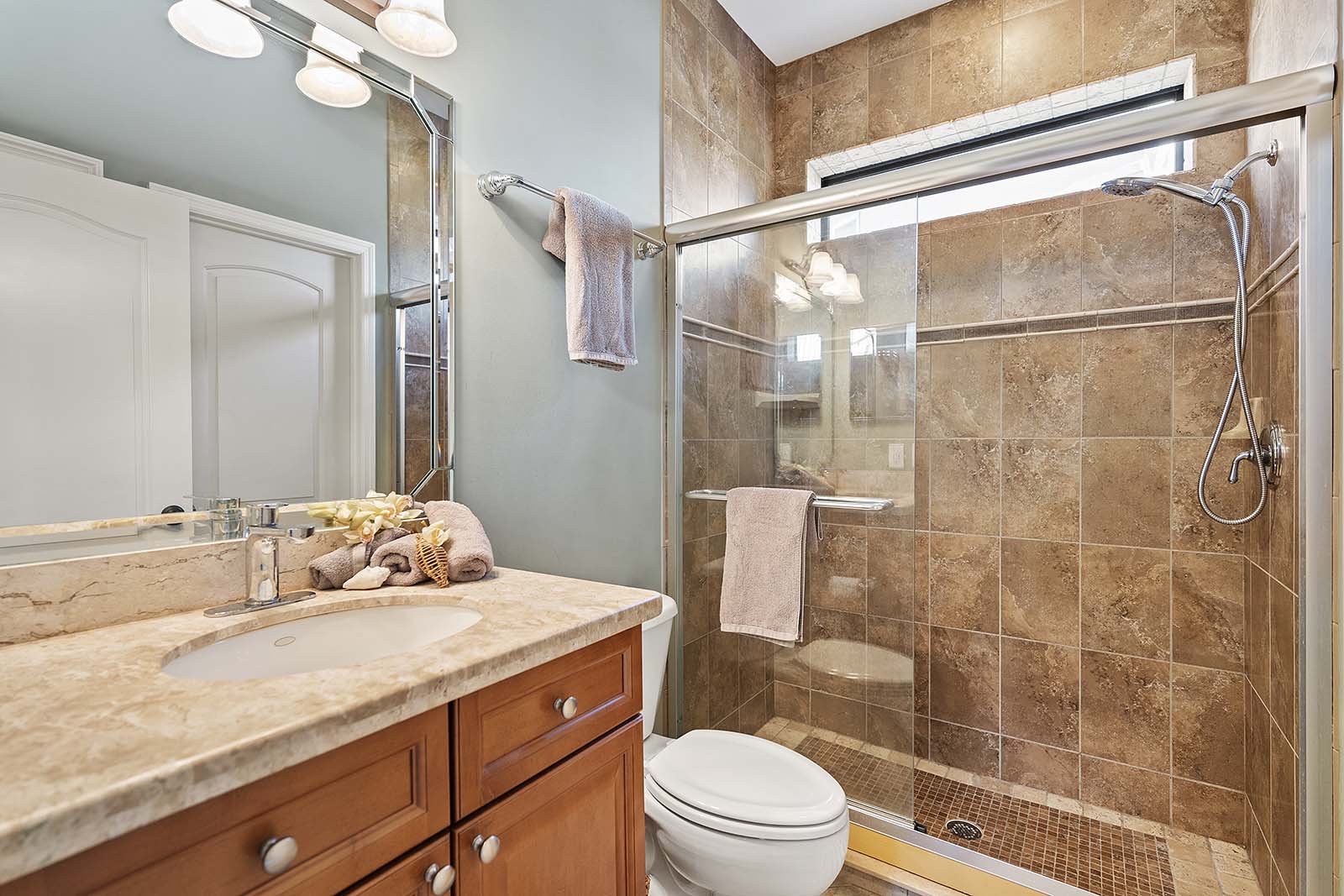 Pool- und Terrassenbereich mit Blick auf den Kanal und Palmen.