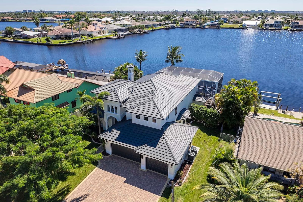 Sonnige Poolterrasse am Kanal mit Bootsdock.