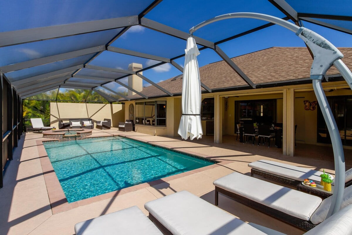 Privater Poolbereich mit Liegen und Blick auf den Kanal.