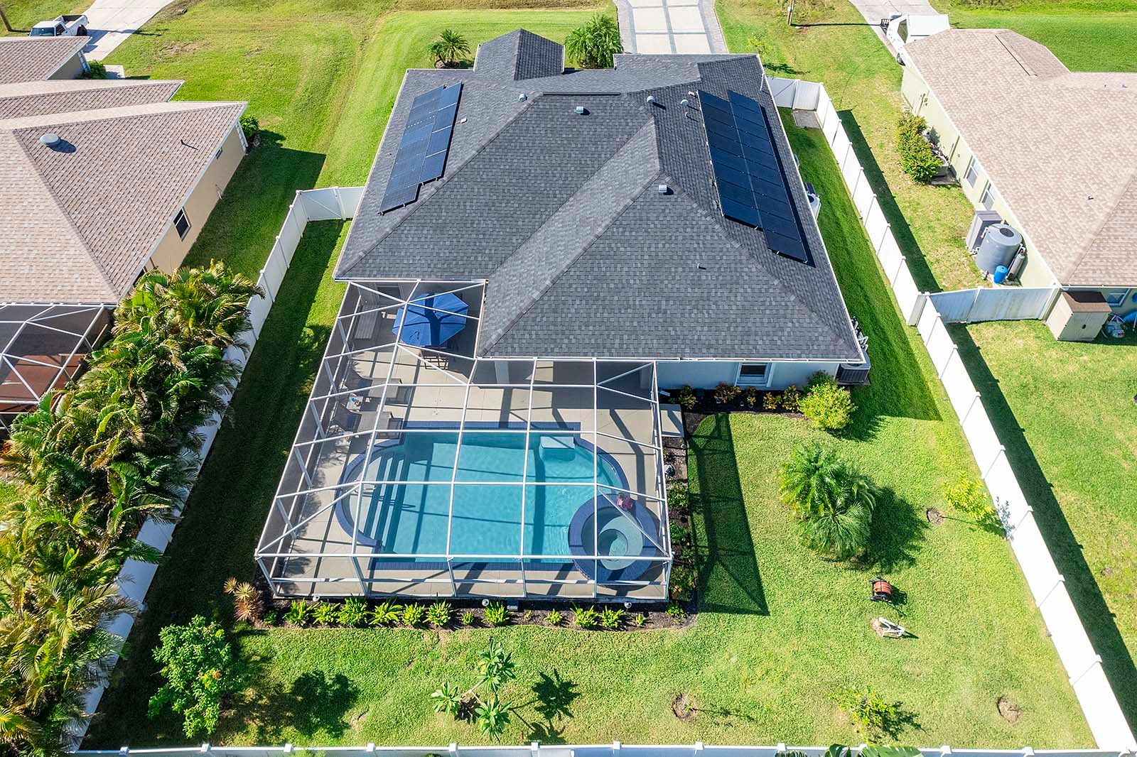 Salzwasser-Pool mit Whirlpool und überdachter Lanai im Garten.