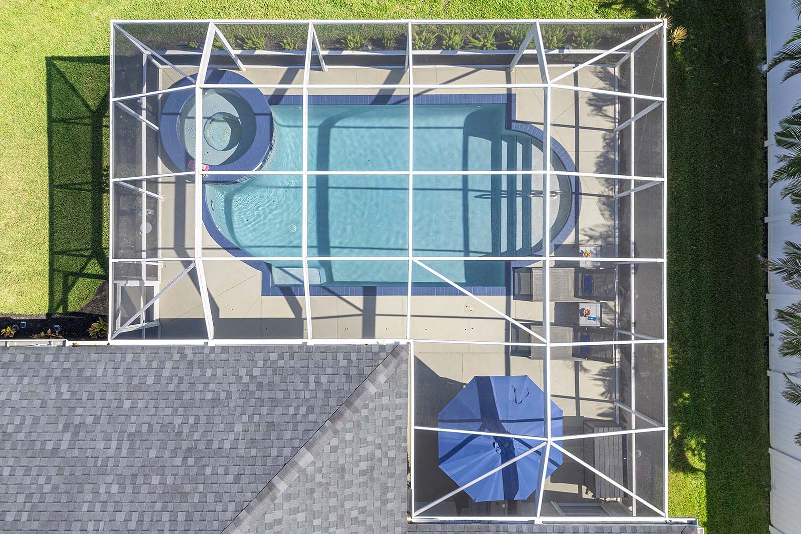 Salzwasser-Pool mit Whirlpool und überdachter Lanai im Garten.