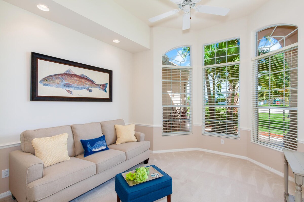 Überdachte Terrasse mit Sitzbereich und Blick auf Pool und Kanal.