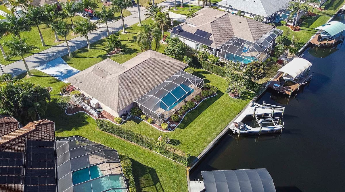 Beheizter Pool mit Sonnenliegen und überdachter Lanai am Kanal.