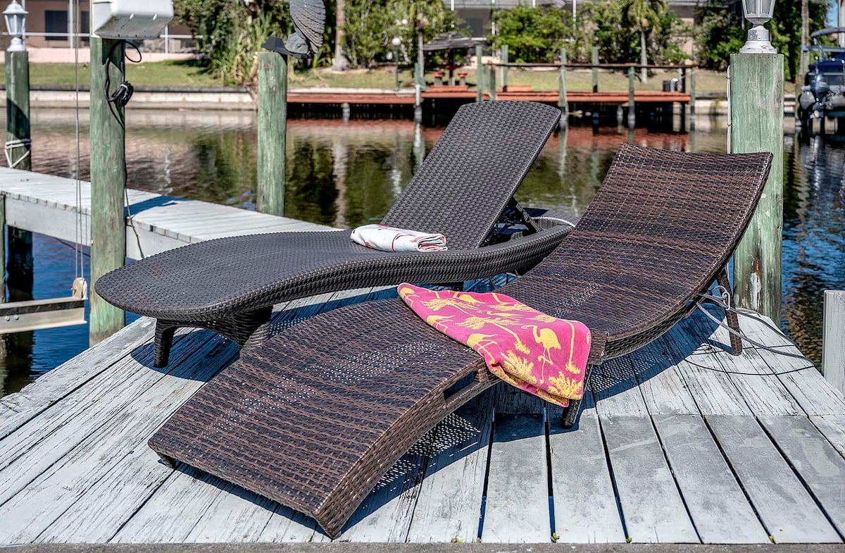 Beheizter Pool mit Sonnenliegen auf der überdachten Terrasse am Kanal.