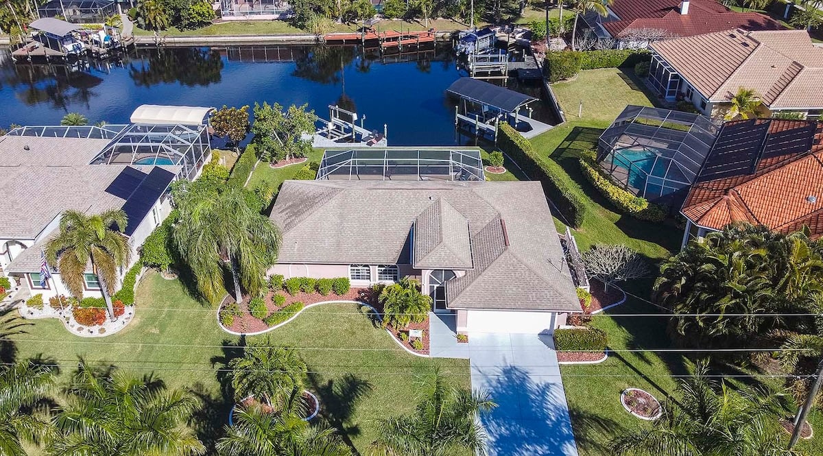 Beheizter Pool mit Sonnenliegen und überdachter Lanai am Kanal.