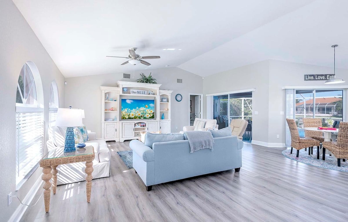 Beheizter Pool mit Sonnenliegen und überdachter Terrasse am Kanal.