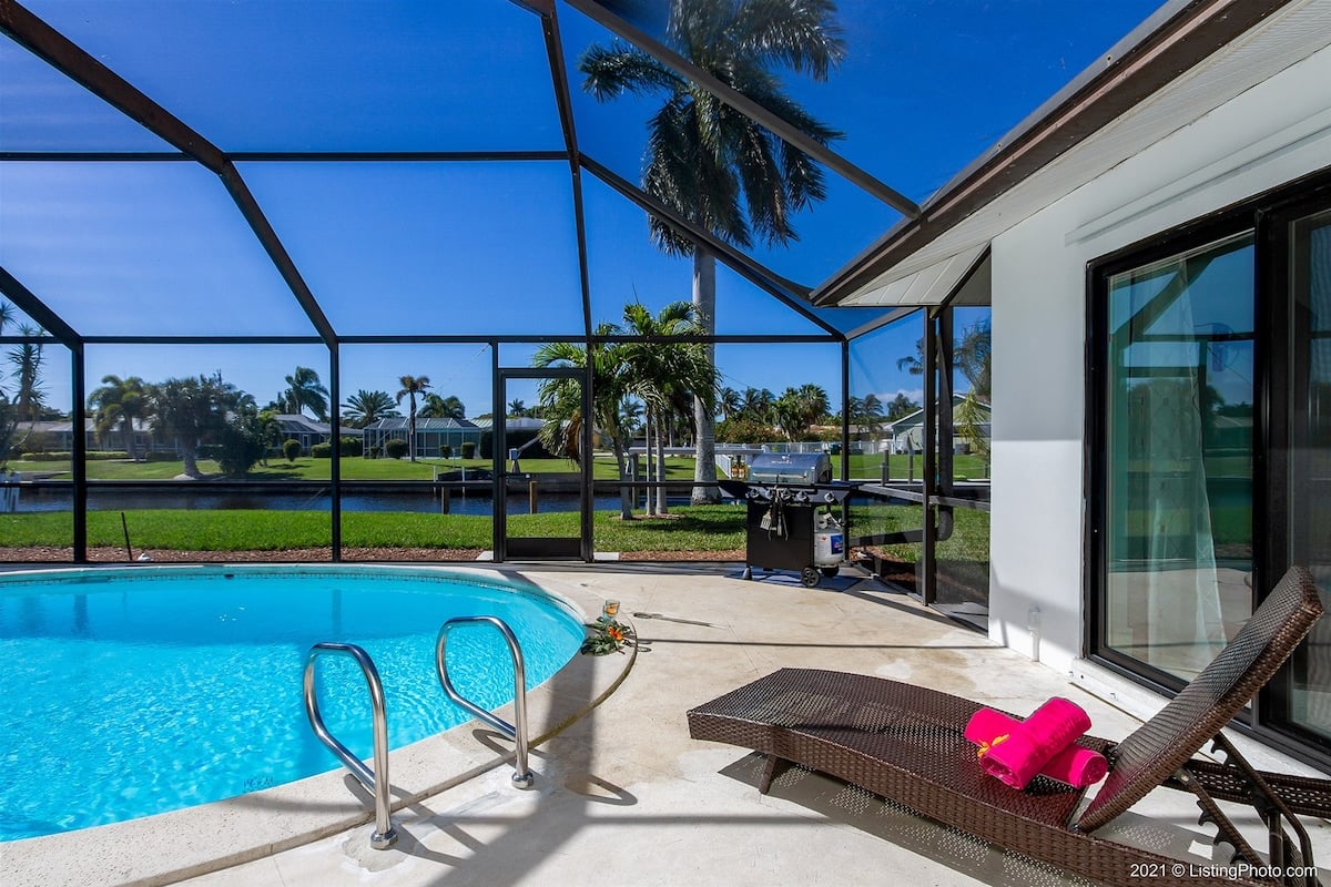 Beheizter Poolbereich mit Blick auf den Kanal und privatem Bootsdock mit Lift.